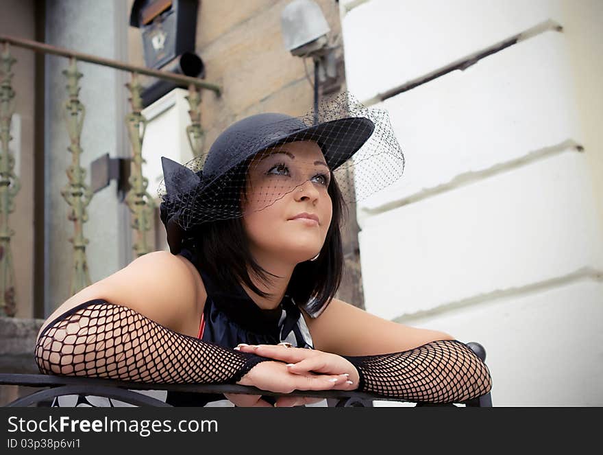 The girl in a hat in an old city in a province