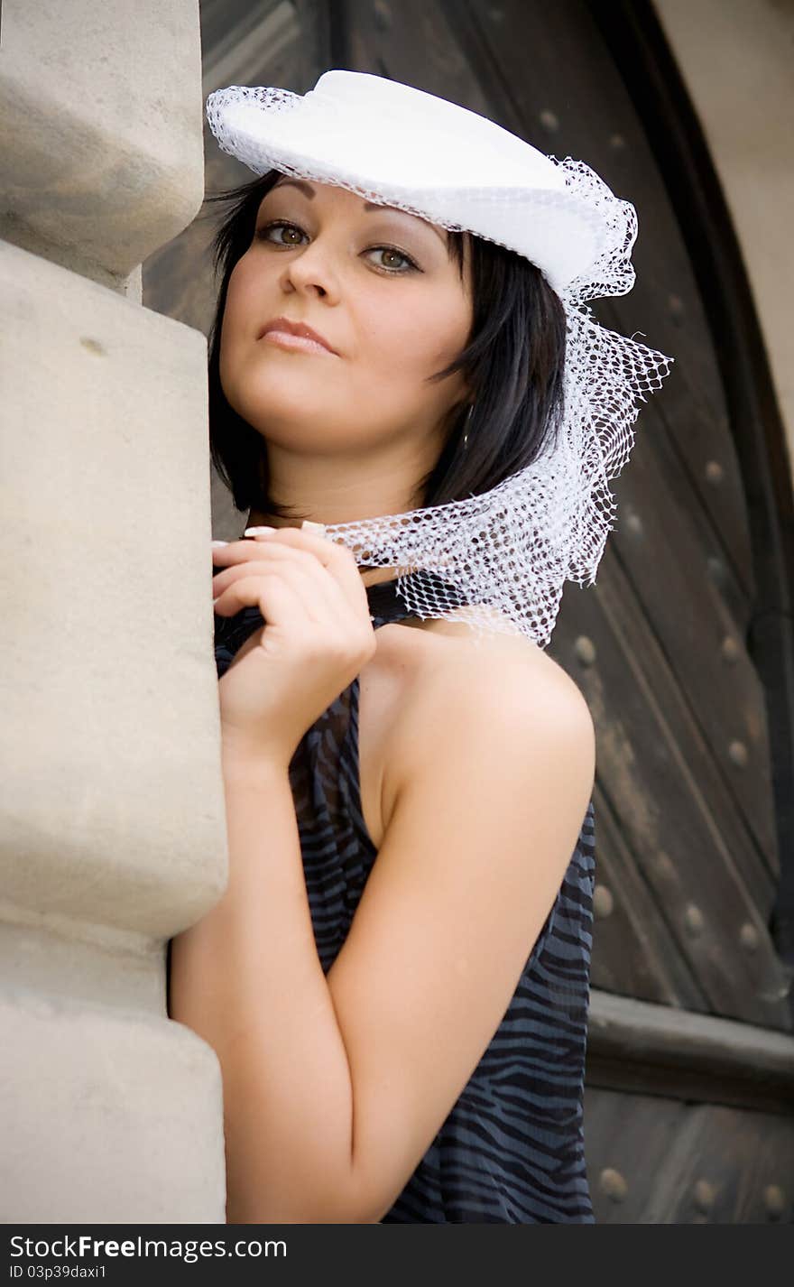 The girl in a hat in an old city in a province