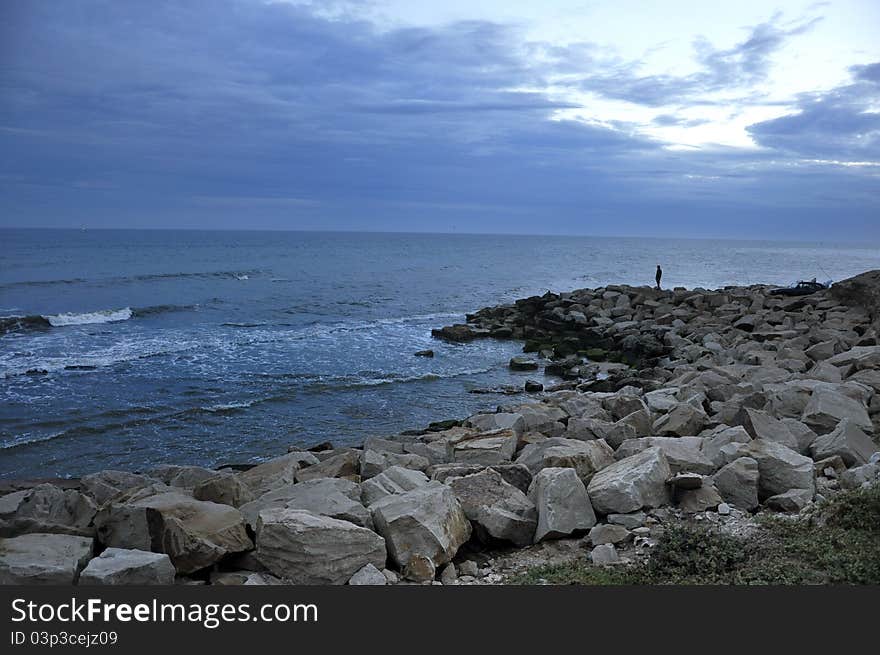 Cost with rock pier, cloudy sky, very blue. Cost with rock pier, cloudy sky, very blue.