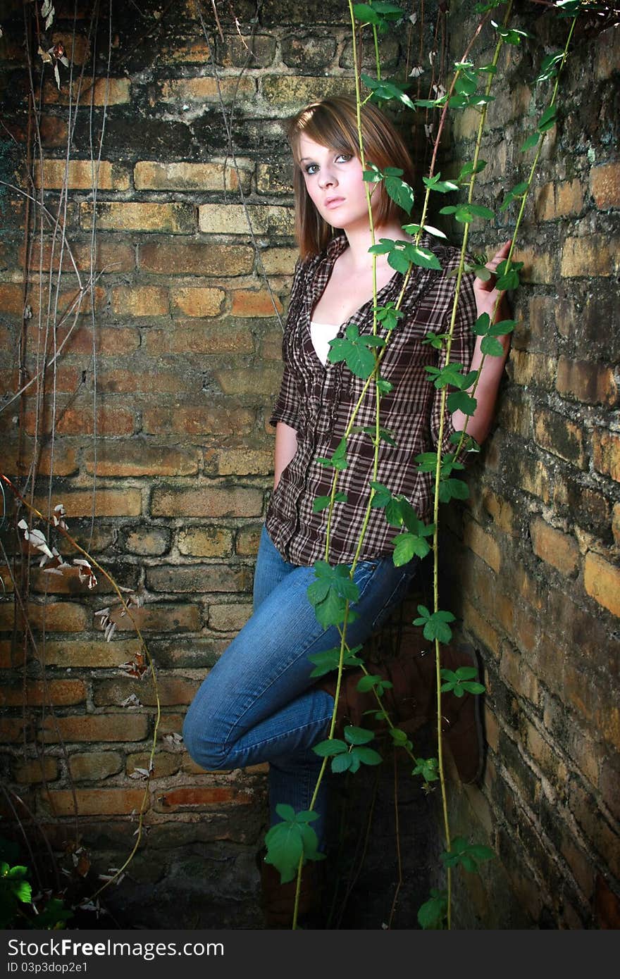 Young woman standing in corner with some vines. Young woman standing in corner with some vines