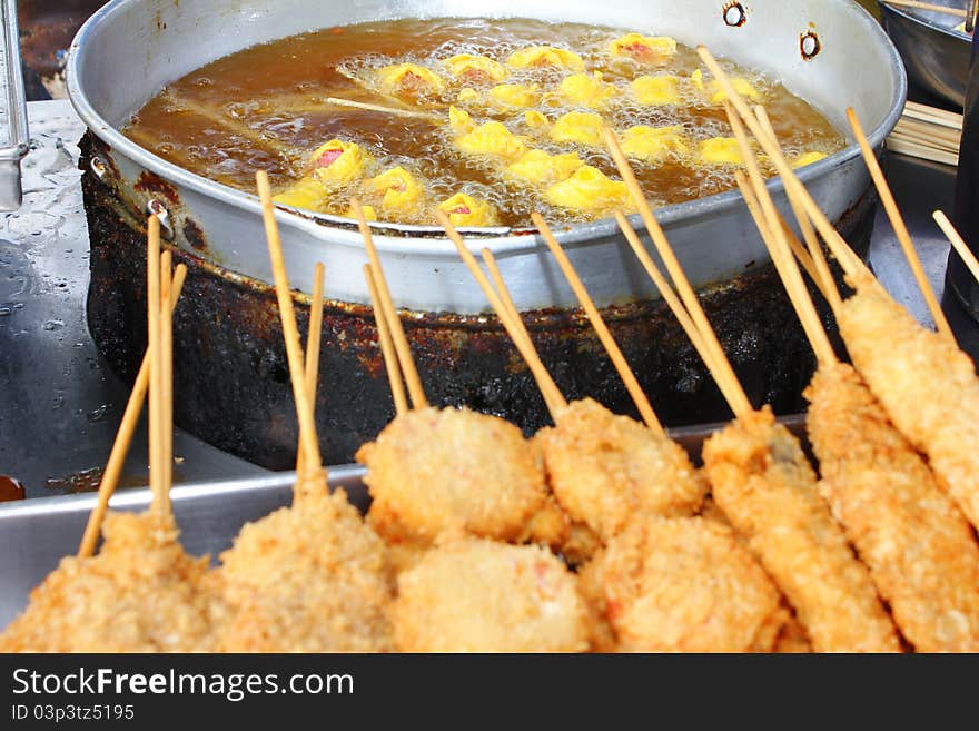 Fried dumplings with skewers food,hot oil