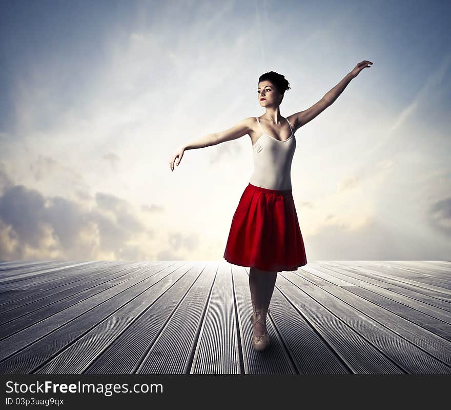 Beautiful ballerina standing on a wooden floor