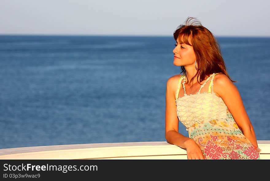 Beautiful woman relaxing wile watching a sea ( ocean ) outdoor. Beautiful woman relaxing wile watching a sea ( ocean ) outdoor