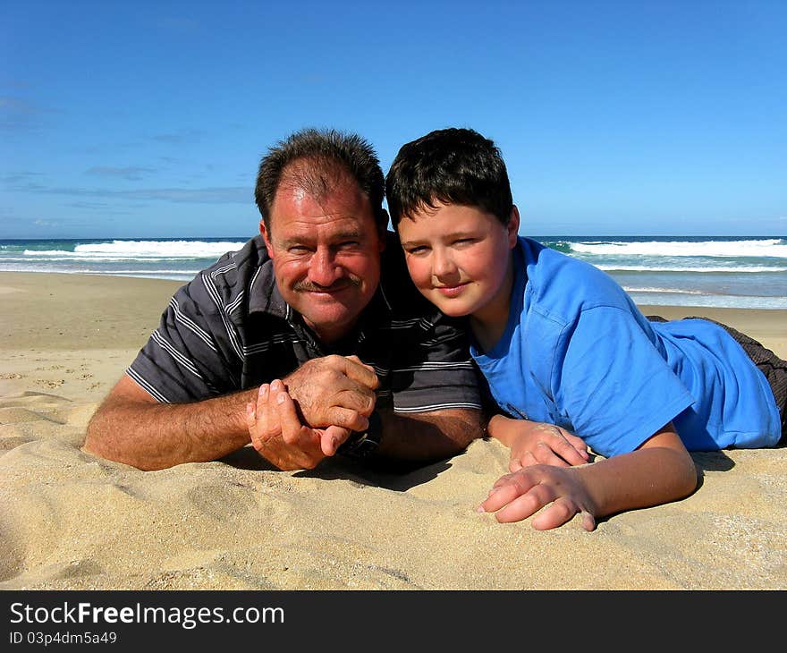 Friendly father and his son on the beach having a good time together. Friendly father and his son on the beach having a good time together.