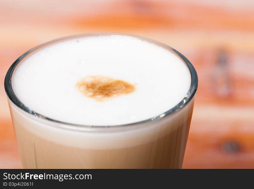 A closeup of the top part of a glass containing a cafe latte style coffee drink. A closeup of the top part of a glass containing a cafe latte style coffee drink.