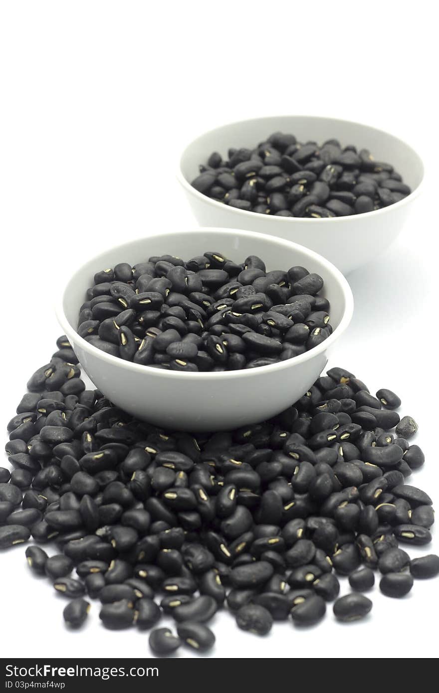 Black beans in cup on a white background.