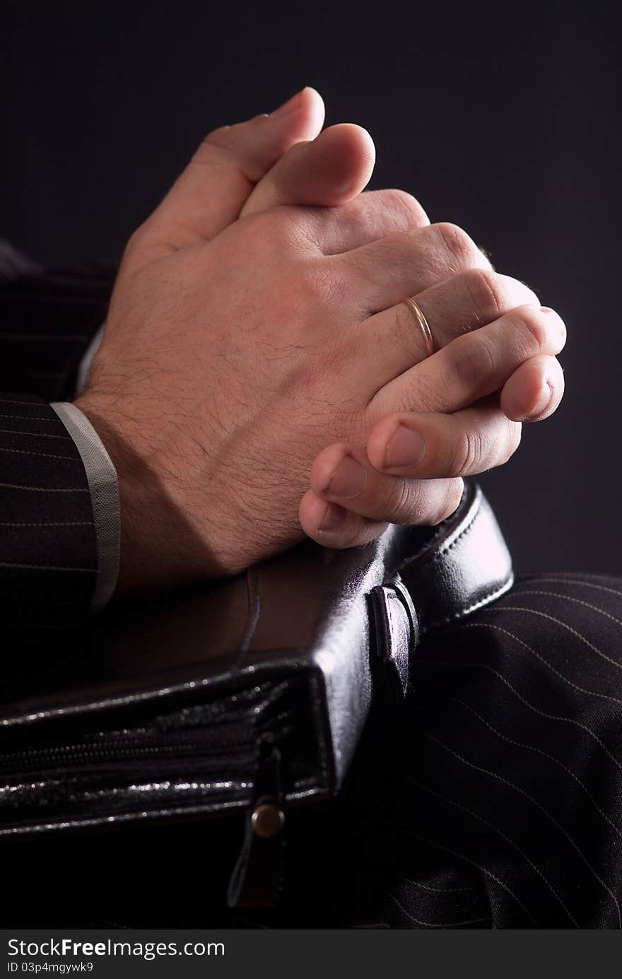 The hands of a businessman carrying a briefcase