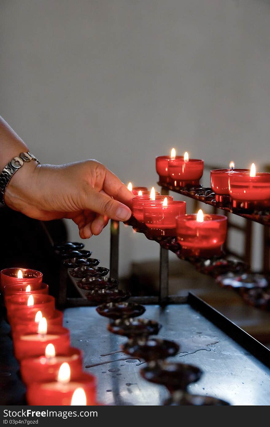 Lightning a candle in a chapel for prayer