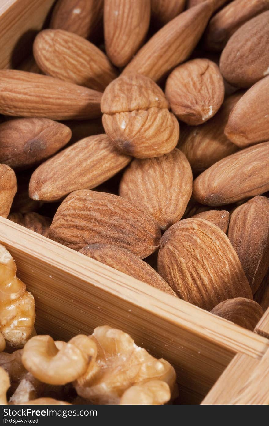 Nuts Almond in a wooden box together with nuts of other grades.