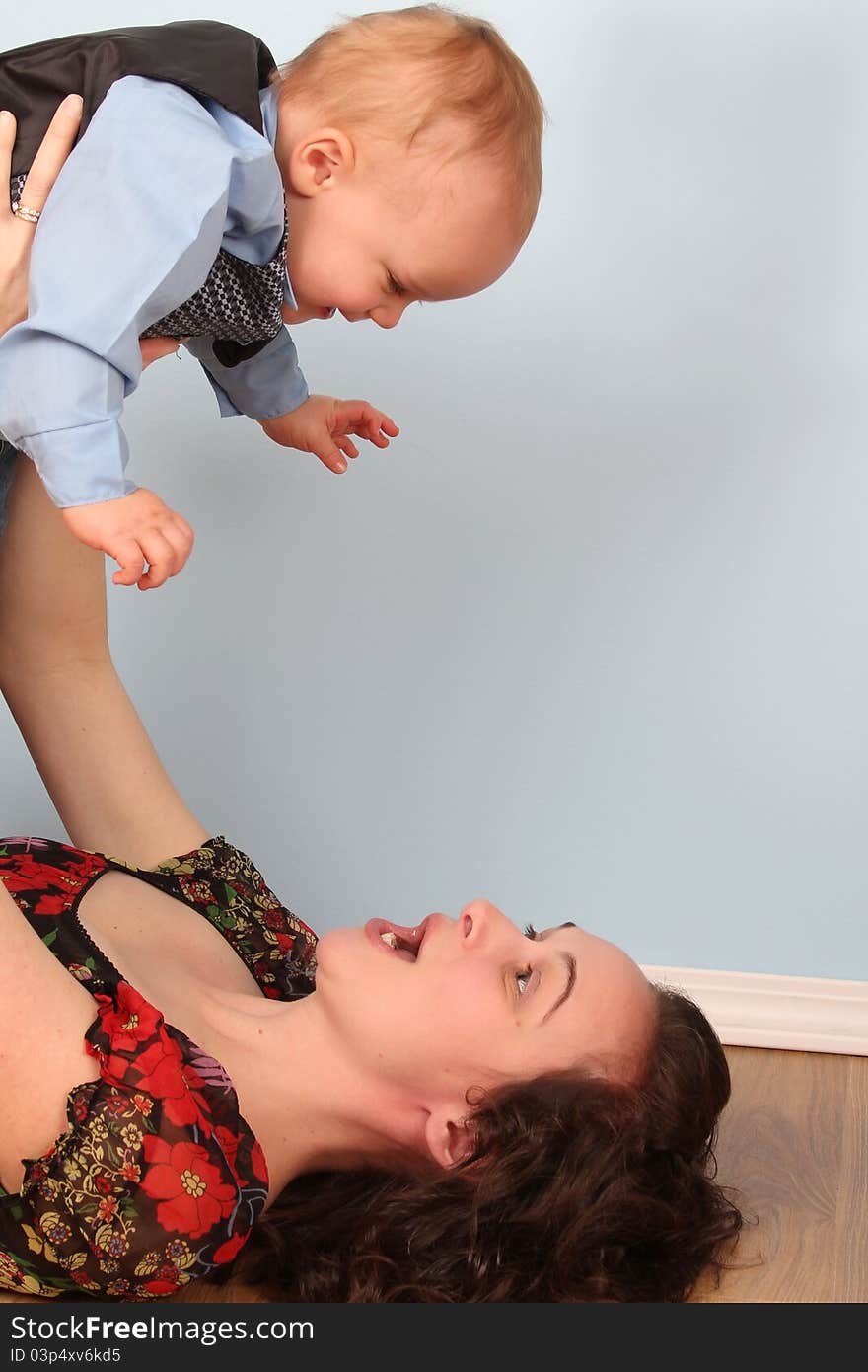 Mother and son playing indoors on a wooden floor