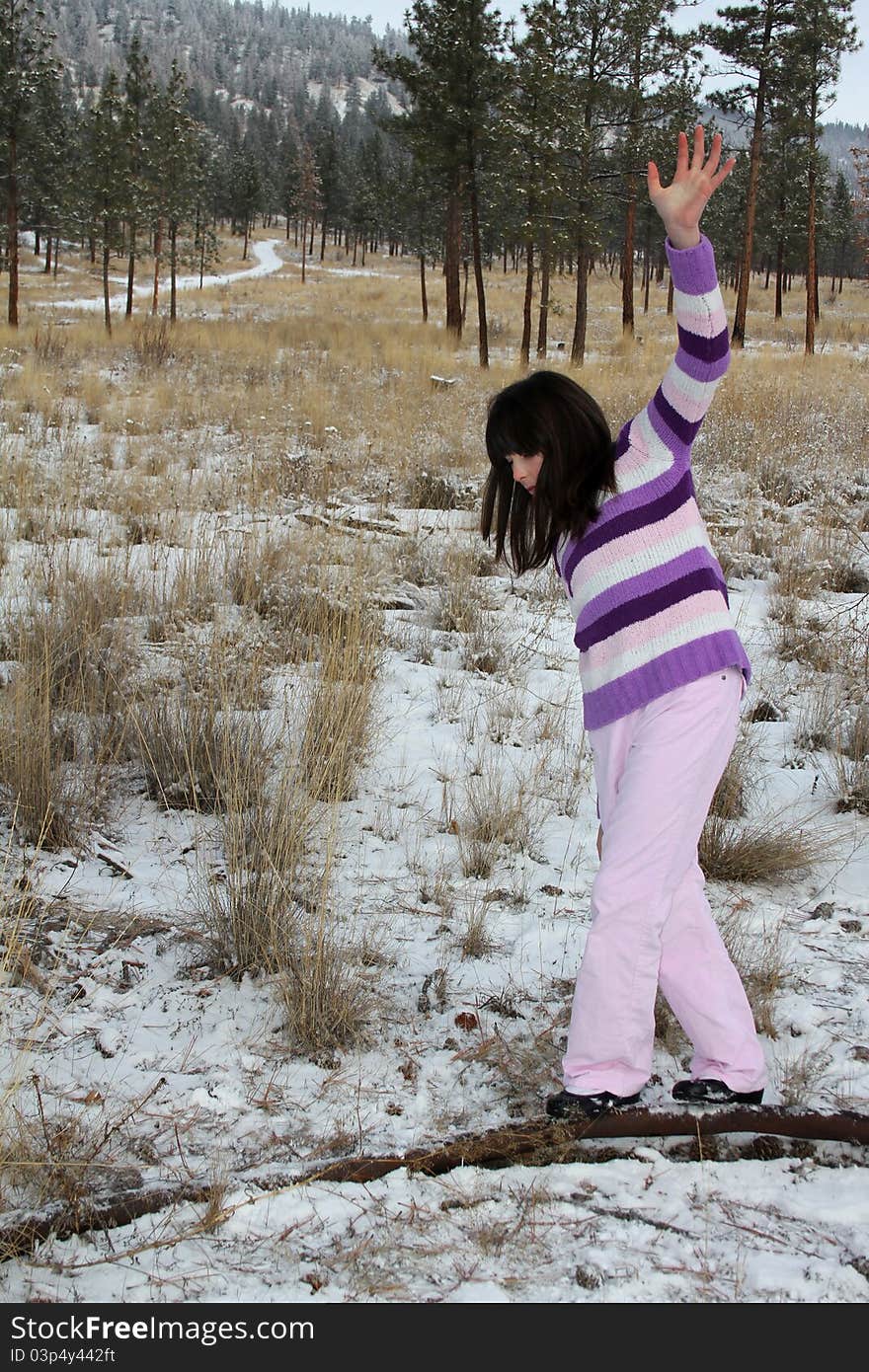 Young brunette teen playing in the field after the snowfall. Young brunette teen playing in the field after the snowfall