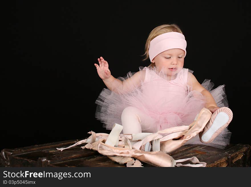 Blond toddler wearing a tutu holding Ballet shoes. Blond toddler wearing a tutu holding Ballet shoes