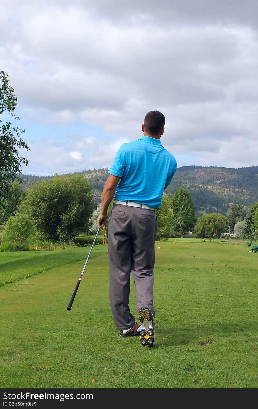 Young golfer looking to see where his ball landed