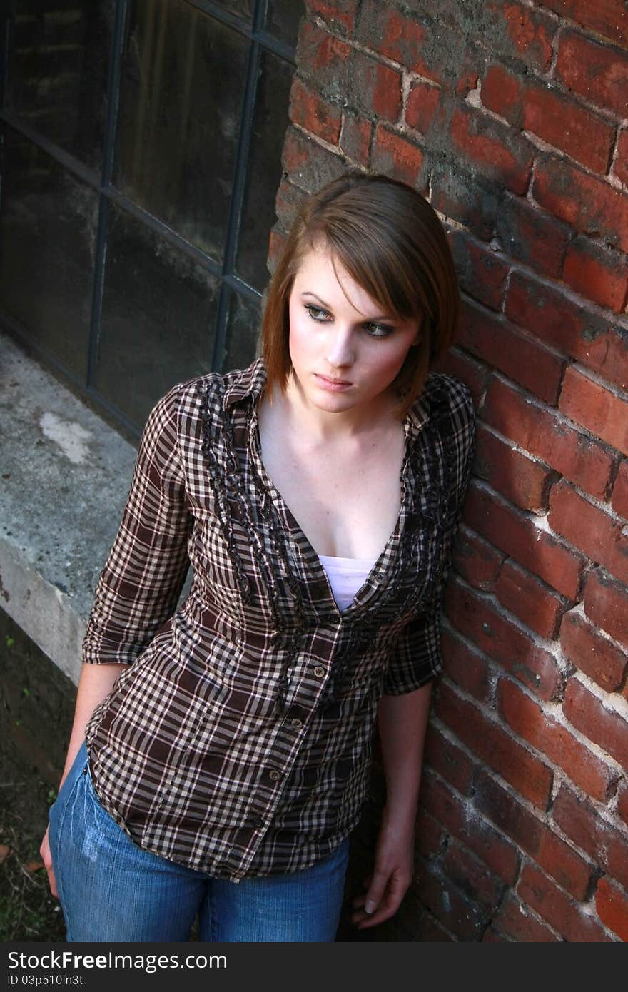 Young Woman Leaning Against Brick Wall