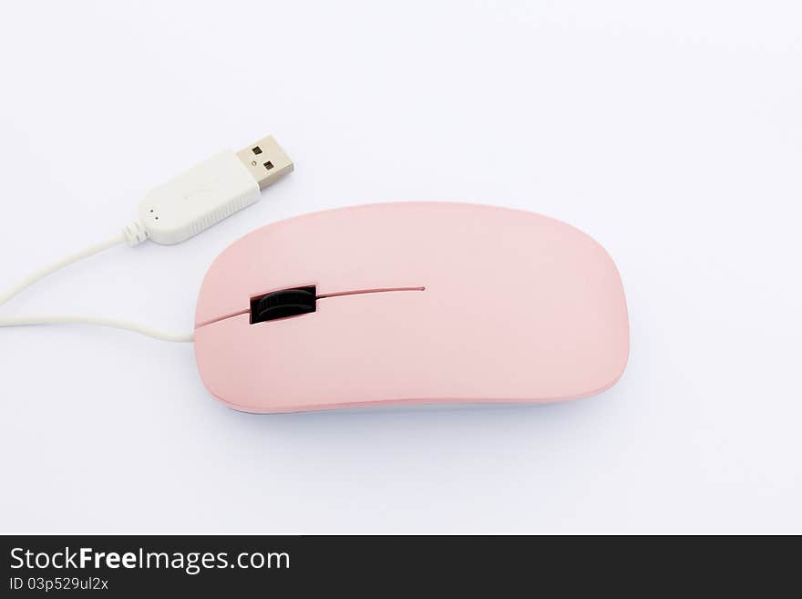 Pink optical mouse with white USB plug on a white background, focus on the mouse. Pink optical mouse with white USB plug on a white background, focus on the mouse