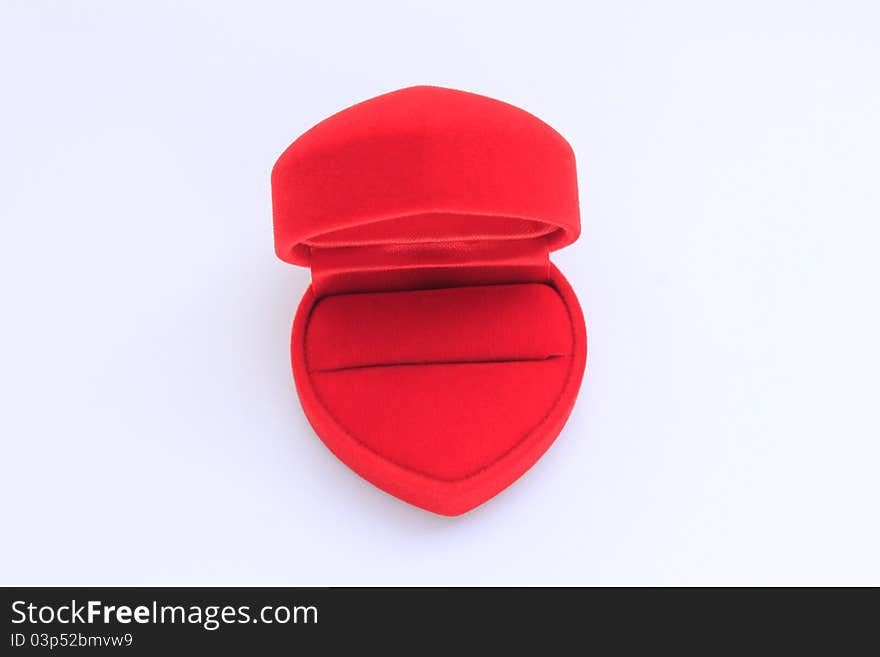 A heart-shaped ring box covered with red velvet on white background