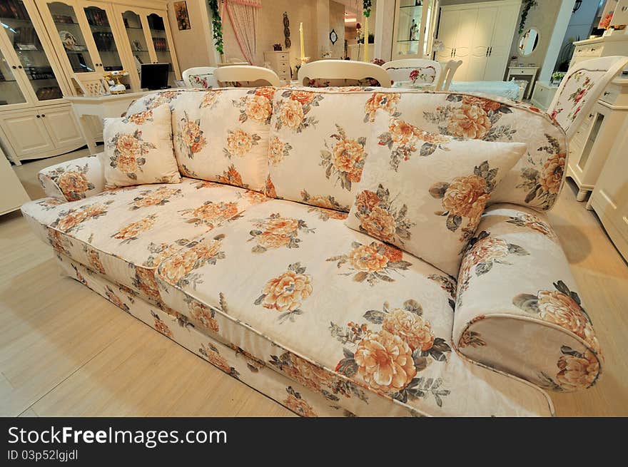 Flowery and comfortable cloth sofa in living room with woodenfurniture, shown as elegance and fine life style. Flowery and comfortable cloth sofa in living room with woodenfurniture, shown as elegance and fine life style.