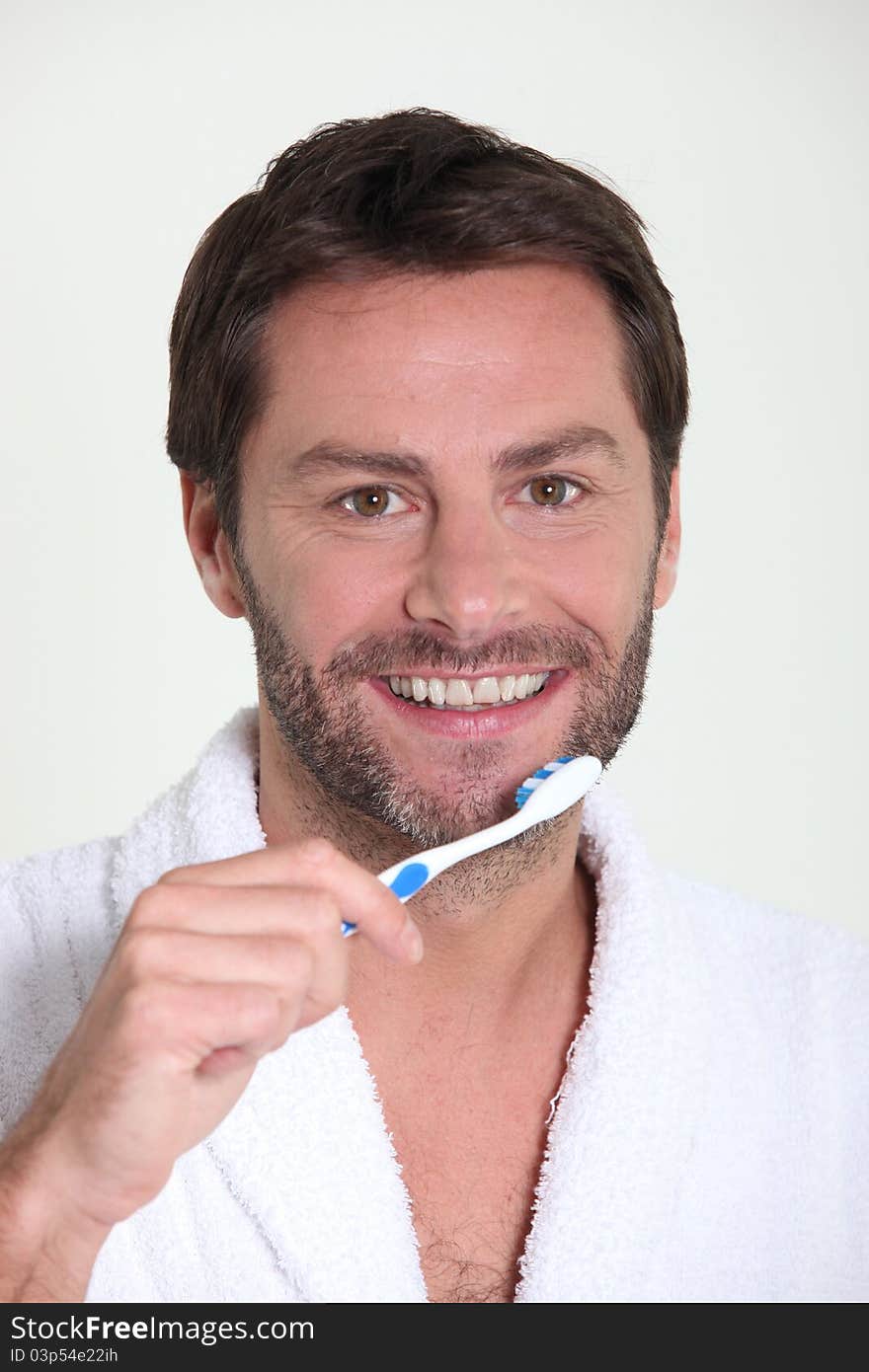 Good looking mature man brushing his teeth in the morning. Good looking mature man brushing his teeth in the morning