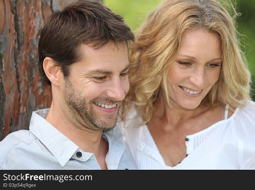 Couple sitting under tree