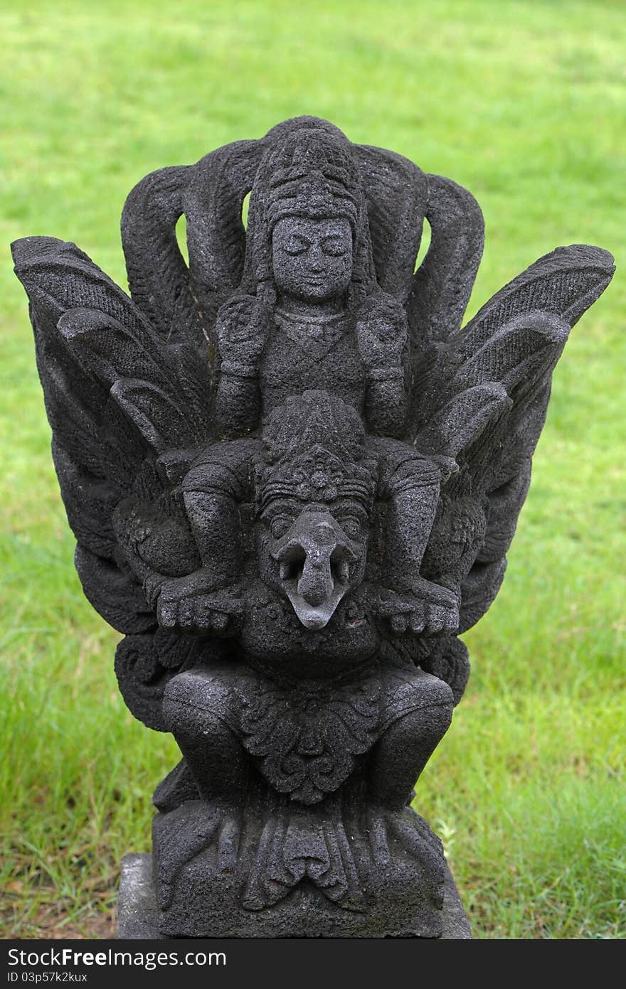 Balinese statue made from rock on grass