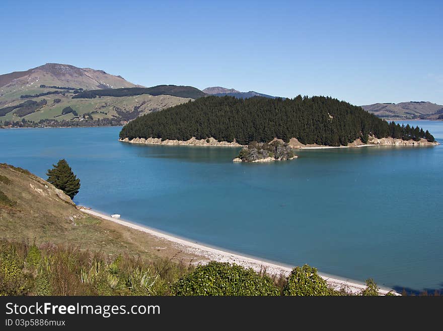 A quiet stretch of Coastline on Quail Island, New Zealand, with just a solitary boat. A quiet stretch of Coastline on Quail Island, New Zealand, with just a solitary boat.