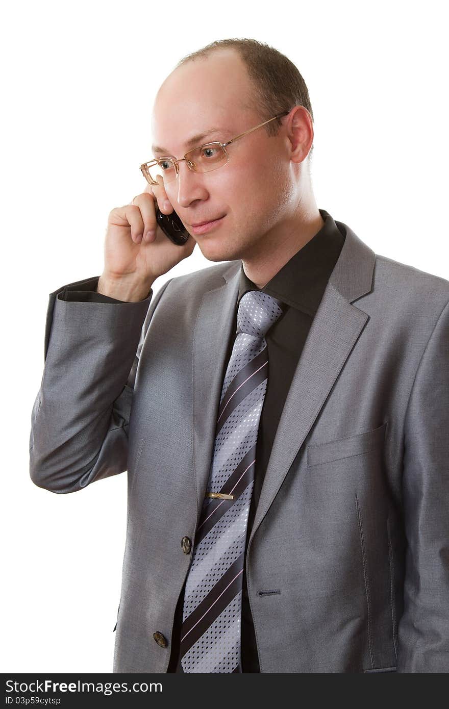 Business man in a gray business suit, tie and glasses does business talks on his cell phone on an isolated white background. Business man in a gray business suit, tie and glasses does business talks on his cell phone on an isolated white background