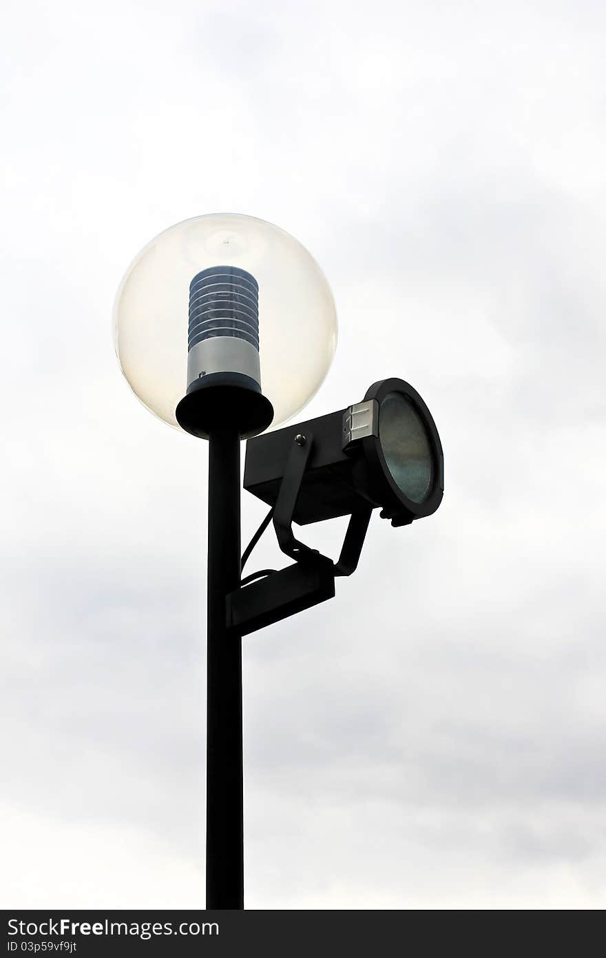 Street lamppost with one spotlight on the backdrop of cloudy sky. Street lamppost with one spotlight on the backdrop of cloudy sky.