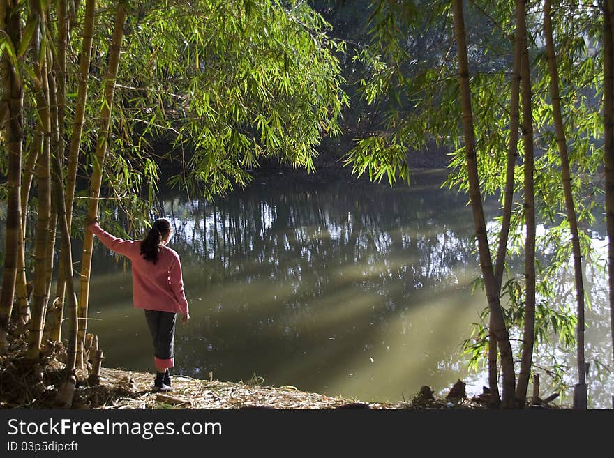 Girl in red sweater keenly watches beauty of nature in morning sunlight. Girl in red sweater keenly watches beauty of nature in morning sunlight