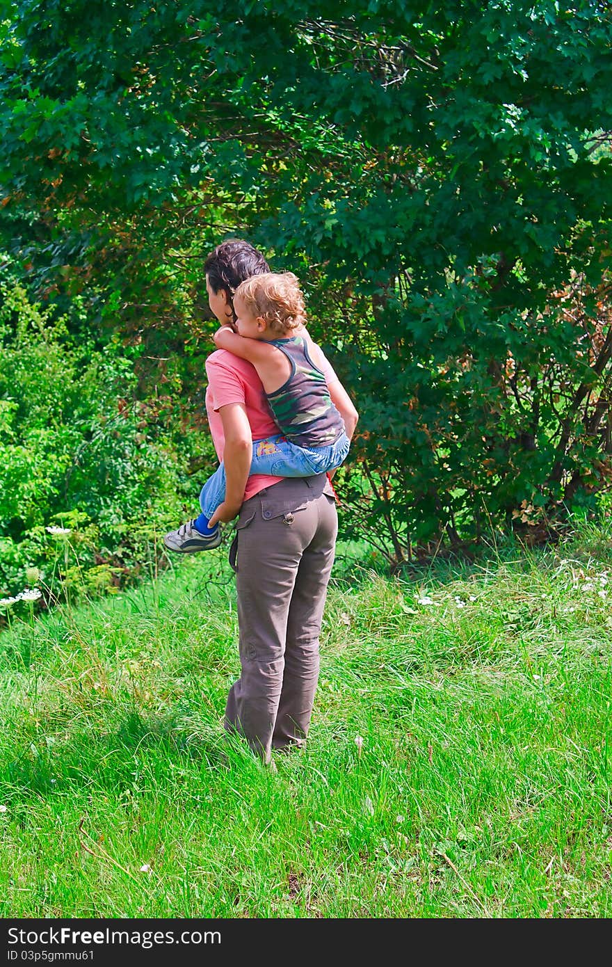 Mother and son in a green forest