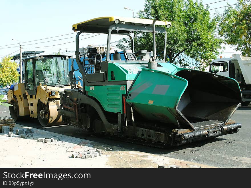 Asphalt compactor and asphalt machine parked. Asphalt compactor and asphalt machine parked.