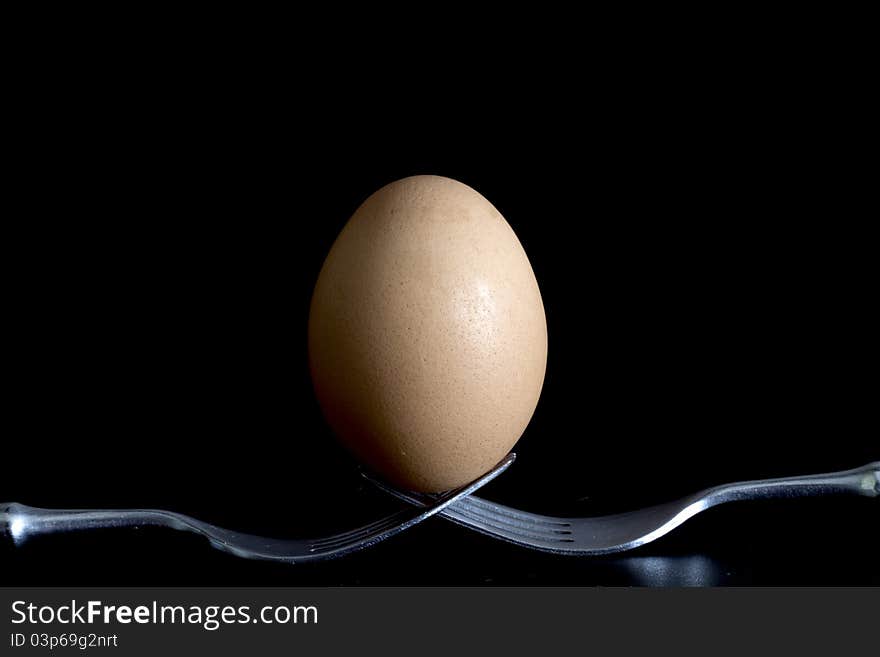 Egg on the bottom supported by two forks