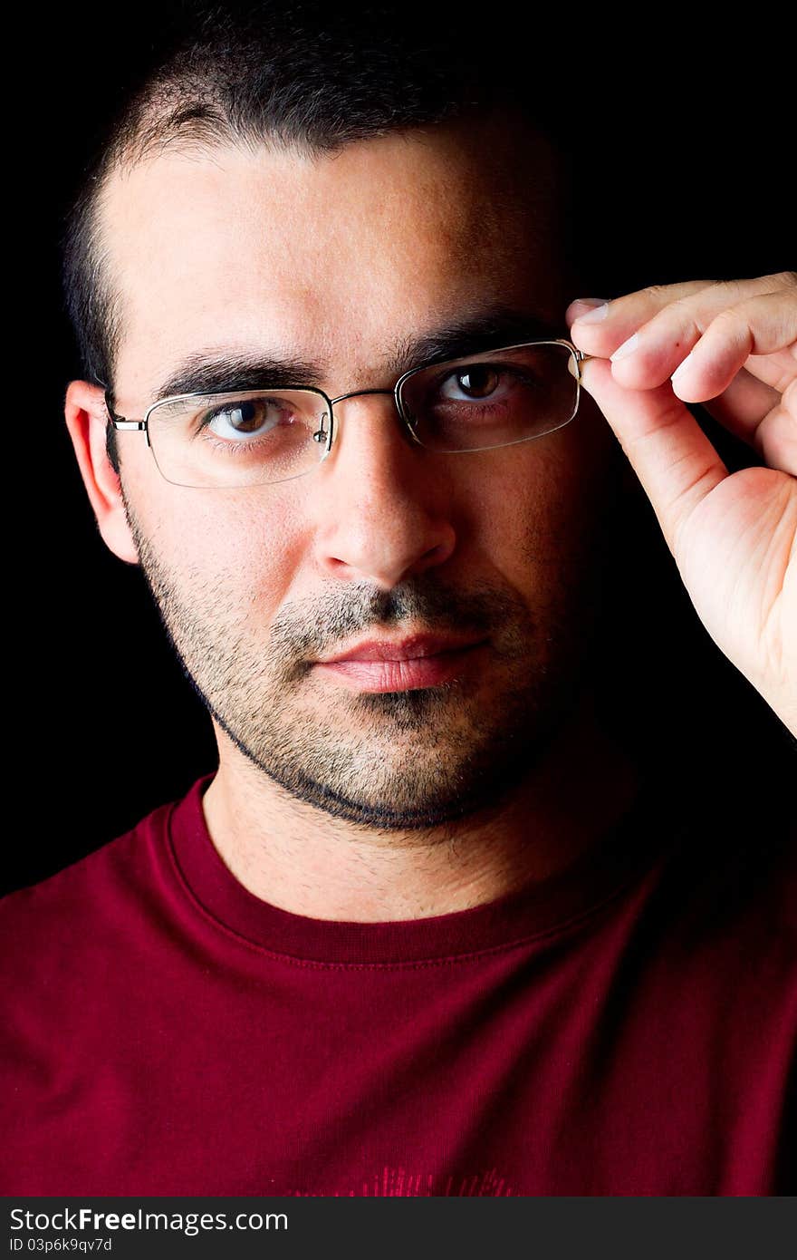 Close detail view of a young male man with glasses isolated on a black background.