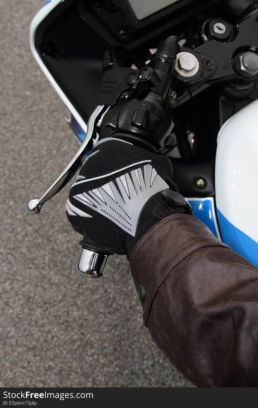 Top view of a biker's hand gripping the handlebar of his motorcycle. Top view of a biker's hand gripping the handlebar of his motorcycle