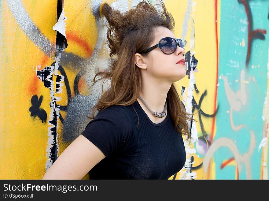 Punk girl standing near graffiti