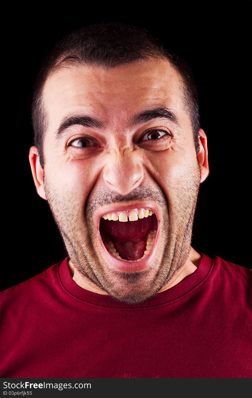 Close detail view of a screaming young male man isolated on a black background. Close detail view of a screaming young male man isolated on a black background.