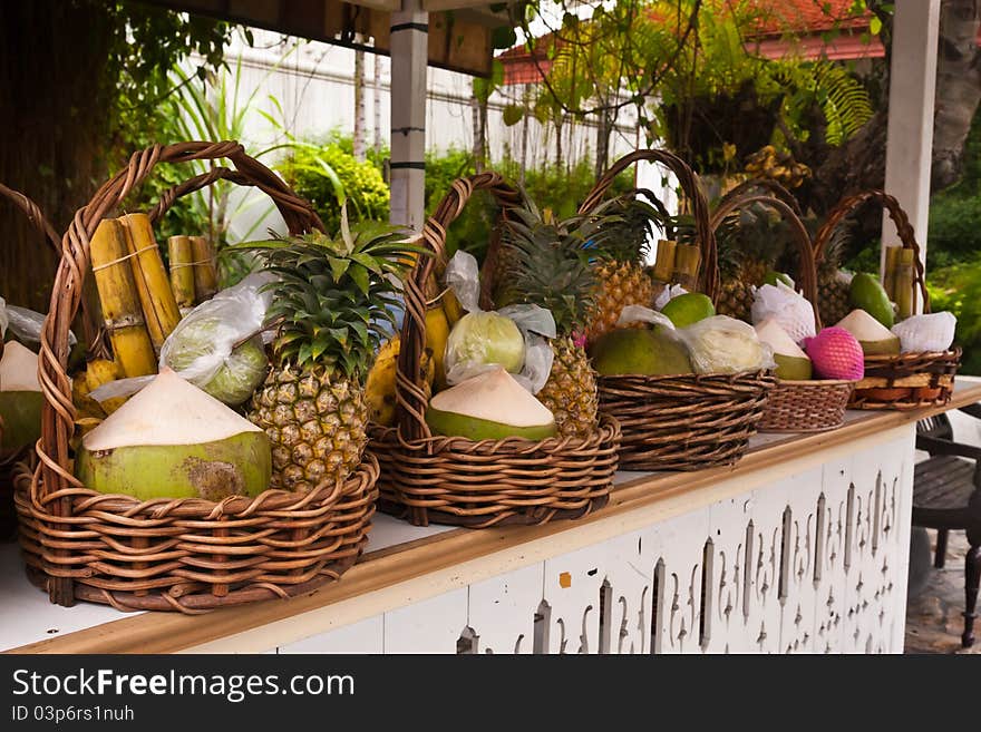 Fruits in basket on shelves included bananas sugarcanes coconuts and pineapples tilted right. Fruits in basket on shelves included bananas sugarcanes coconuts and pineapples tilted right