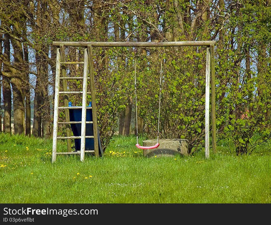 Red garden swing in a small outdoors garden