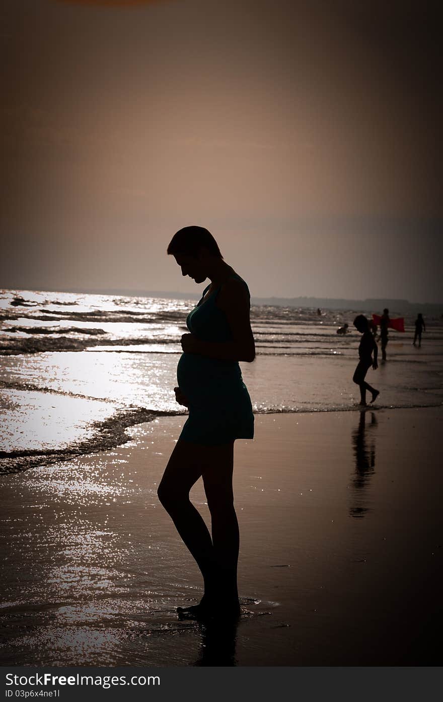 Woman standing on beach wit back light