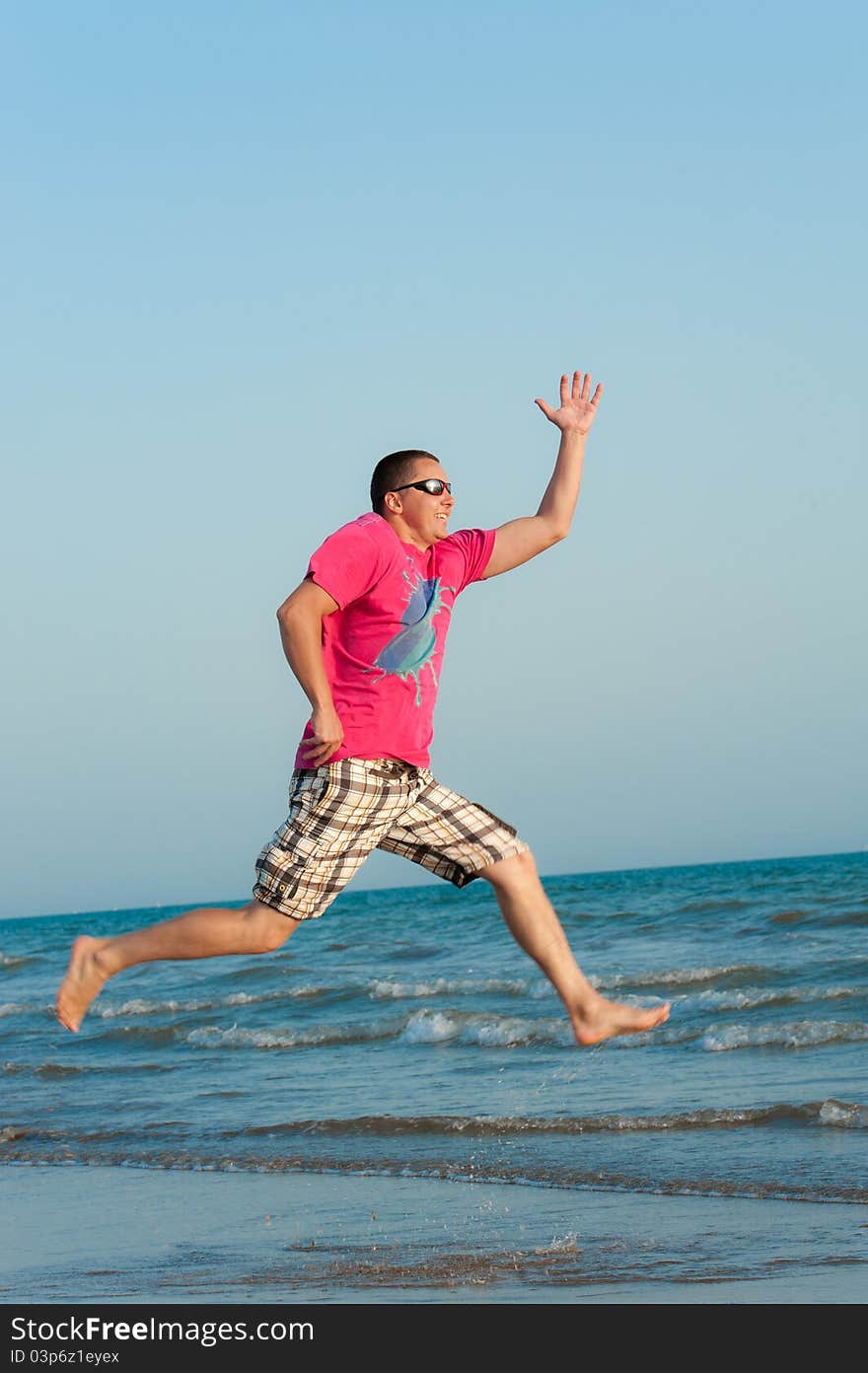 Young man jumping in the ocean