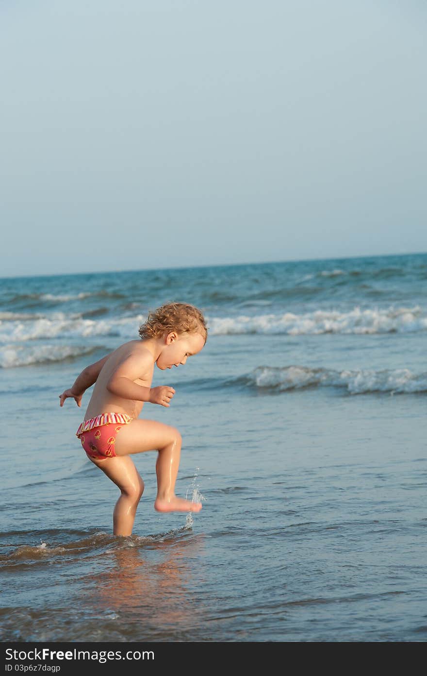 Child is walking in ocean water