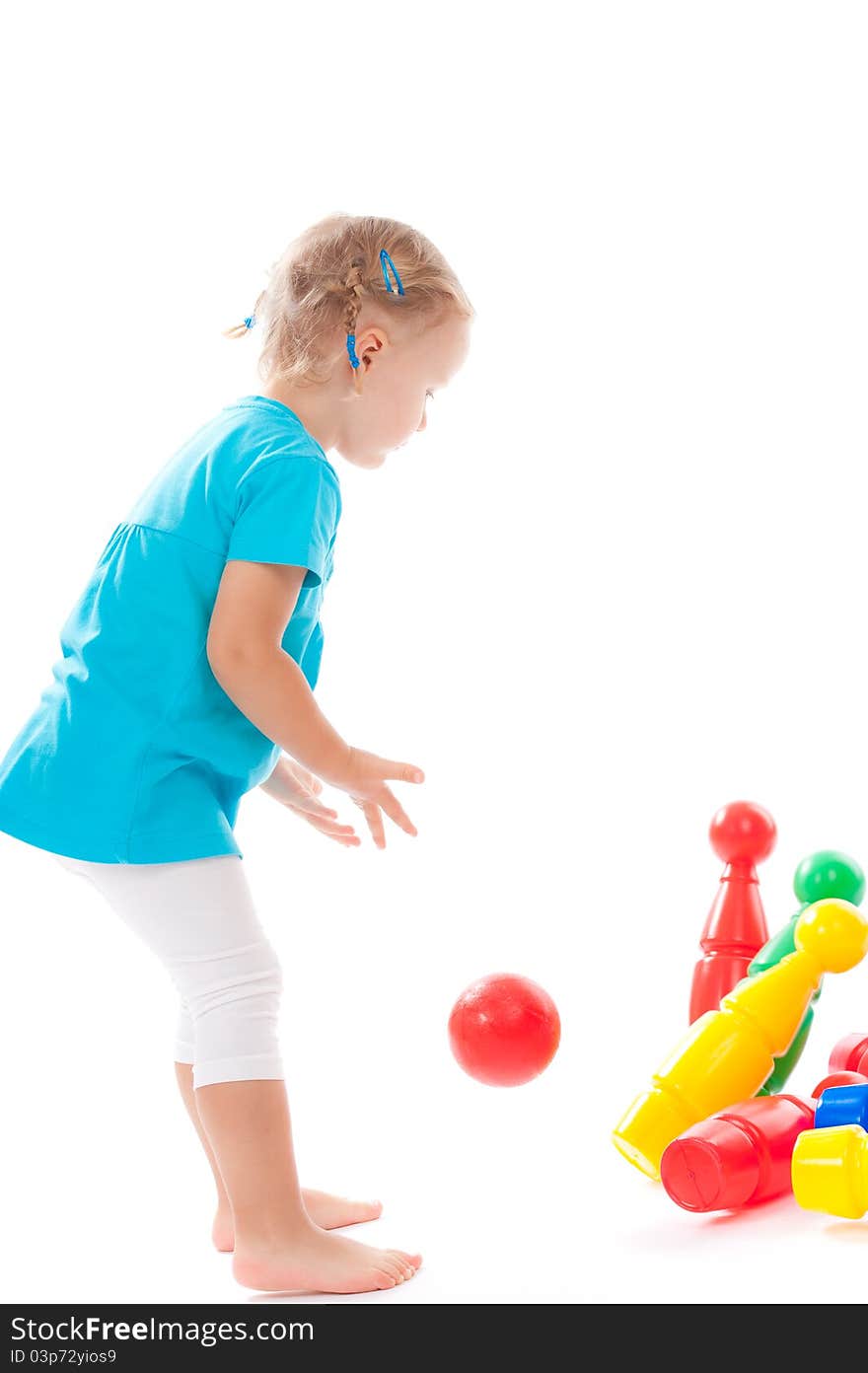 Little child is playing bowls in studio