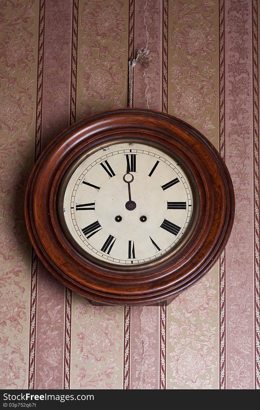 Retro wall clock on a background of vintage wallpaper