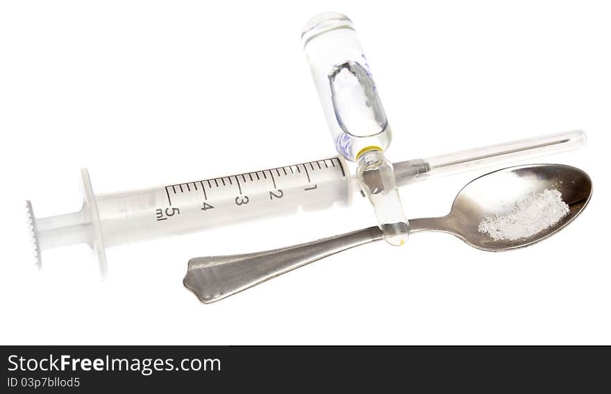 Spoon, syringe, vial on a white