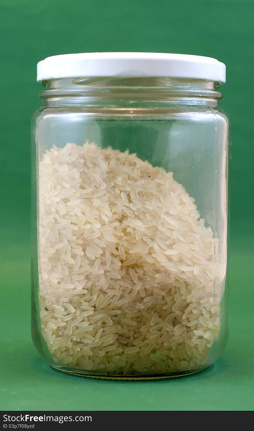 Bottle with rice foreground green background