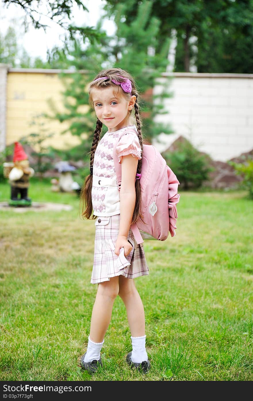 Young girl with pink backpack ready for school