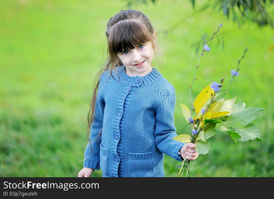 Adorable child girl poses outdoors in blue sweater. Adorable child girl poses outdoors in blue sweater