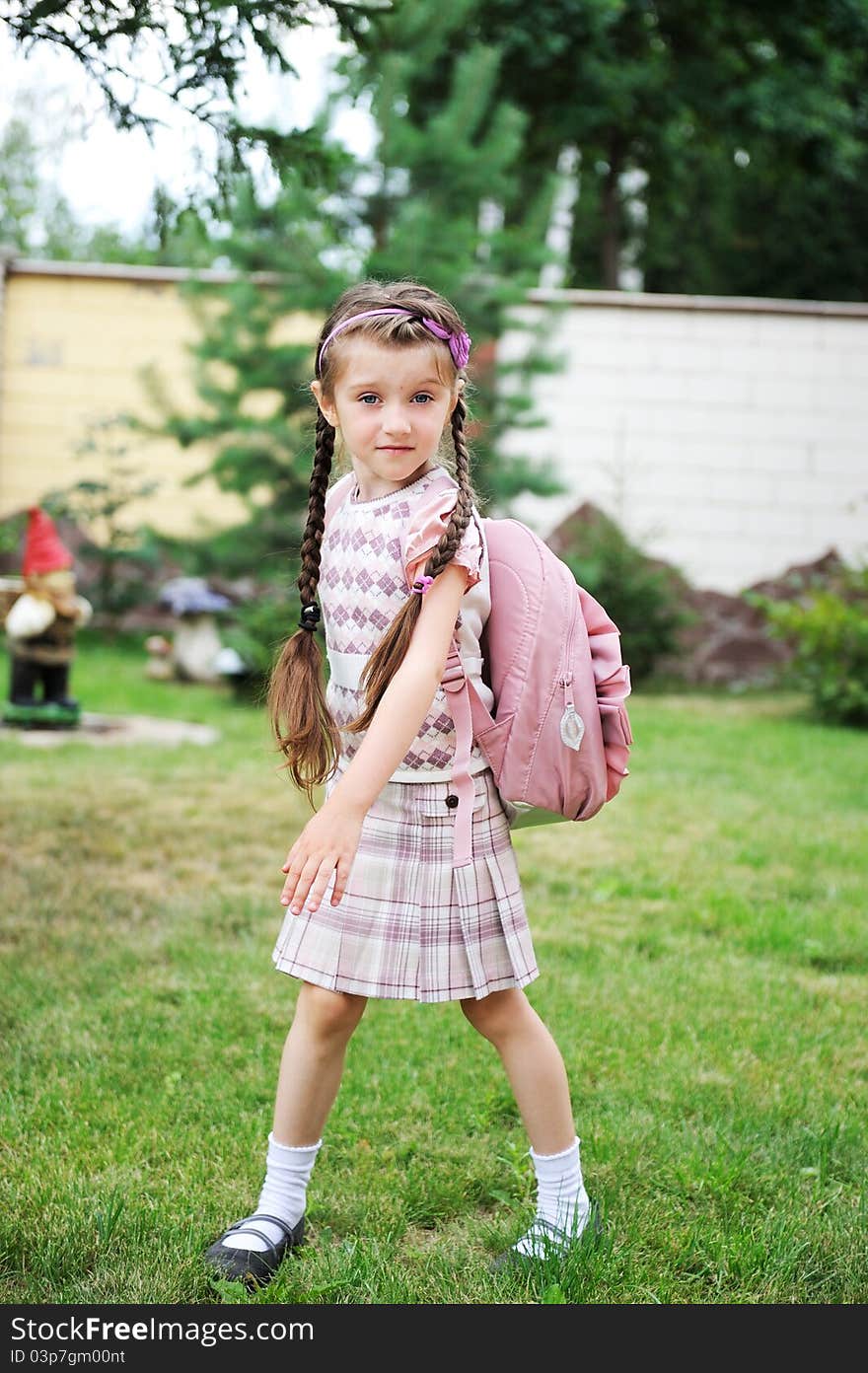 Young girl with pink backpack ready for school