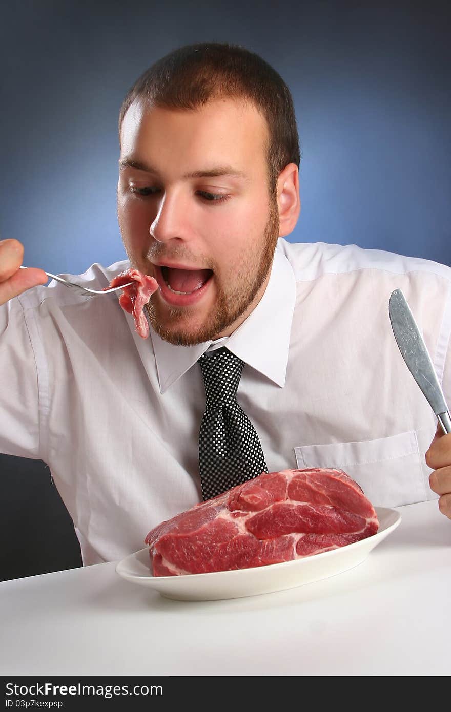 Eccentric guy eating red meat. Eccentric guy eating red meat