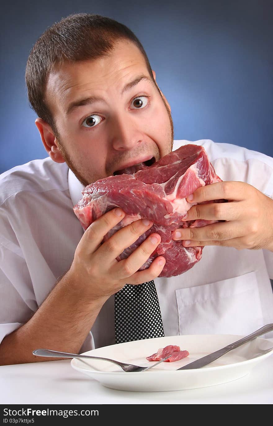 Eccentric guy eating red meat. Eccentric guy eating red meat