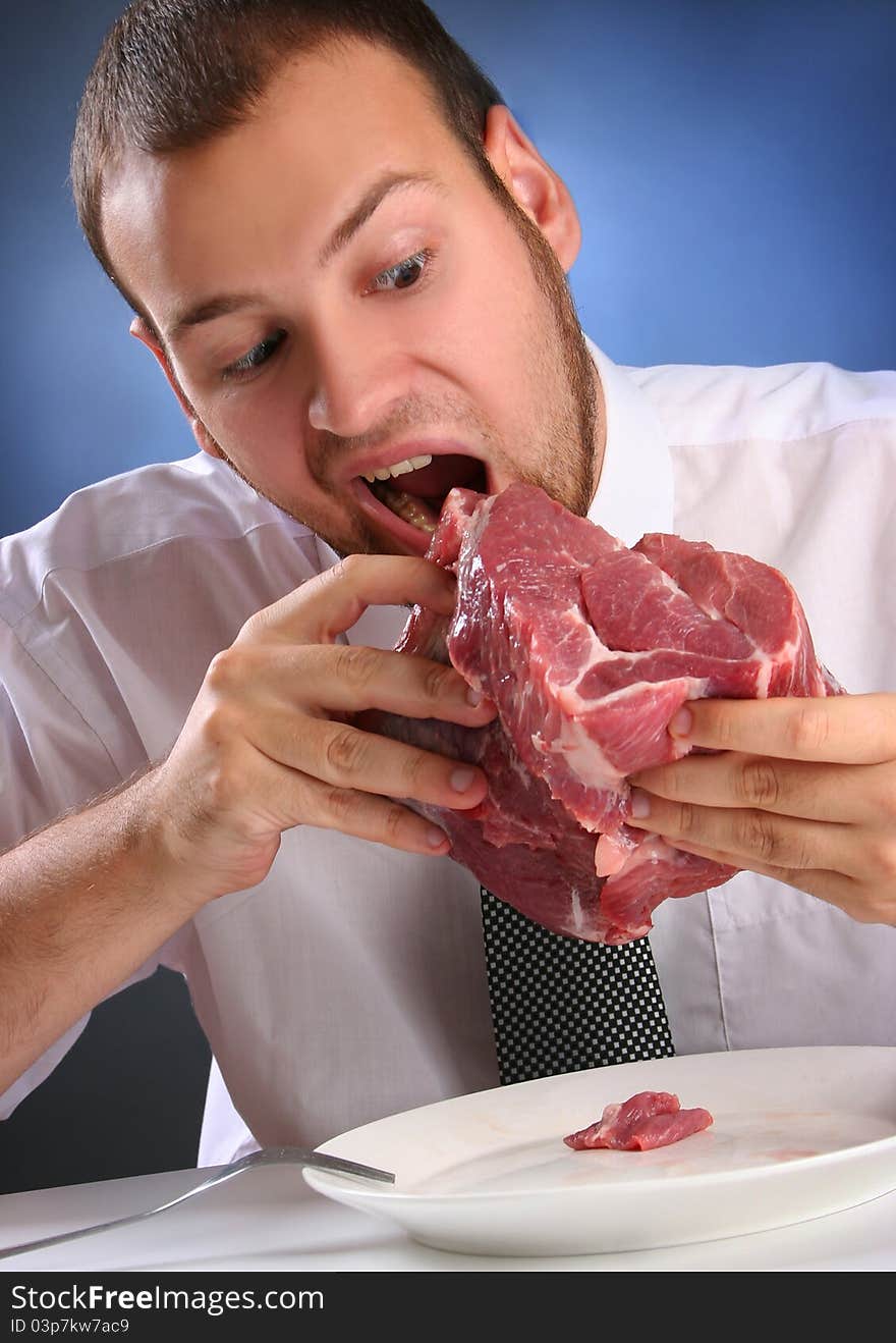 Eccentric guy eating red meat. Eccentric guy eating red meat